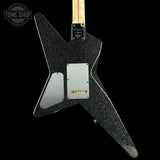 Black electric guitar with a unique body shape on a black background, featuring 'Tone Shop' branding.