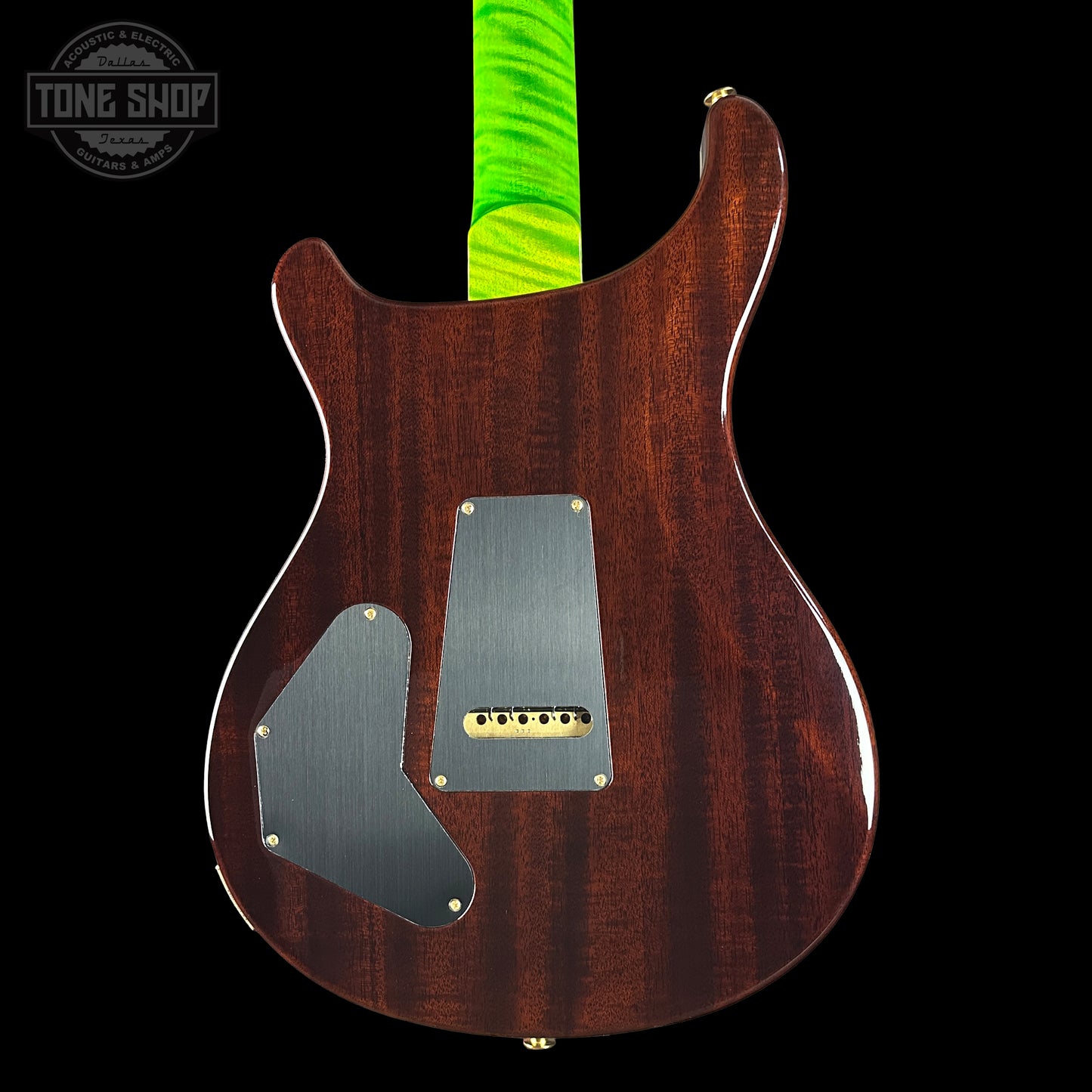 Back view of a wooden electric guitar with a green strap on a black background, featuring the Tone Shop logo.