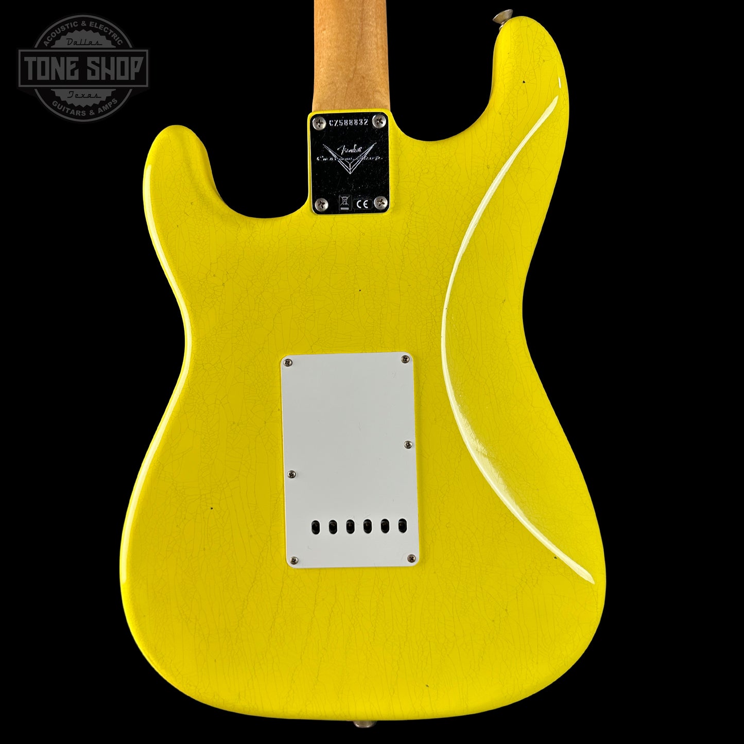 Yellow electric guitar body with a visible brand logo on a black background