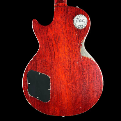 Red electric guitar body with brand logo and specifications on a black background