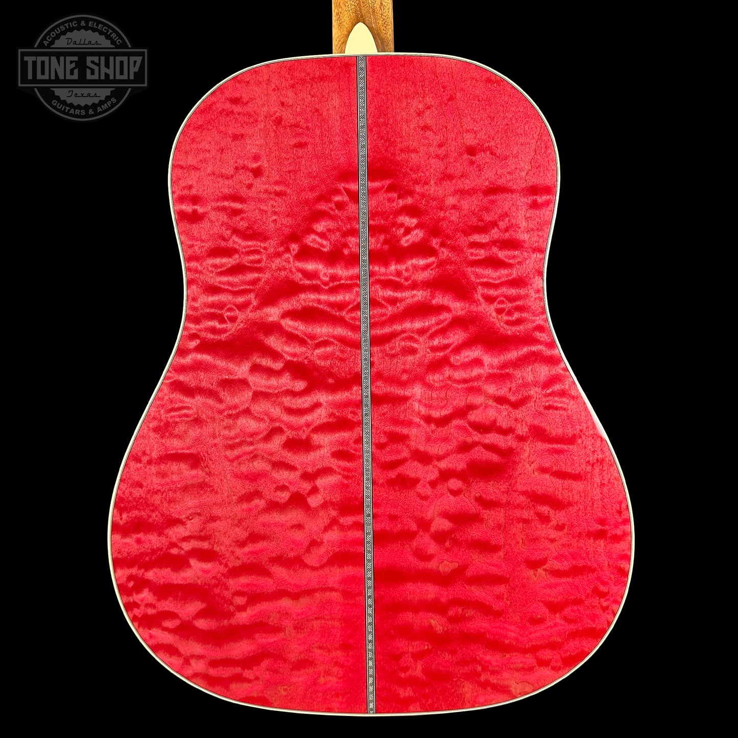 Close-up of a red guitar back with a visible brand logo in the corner.