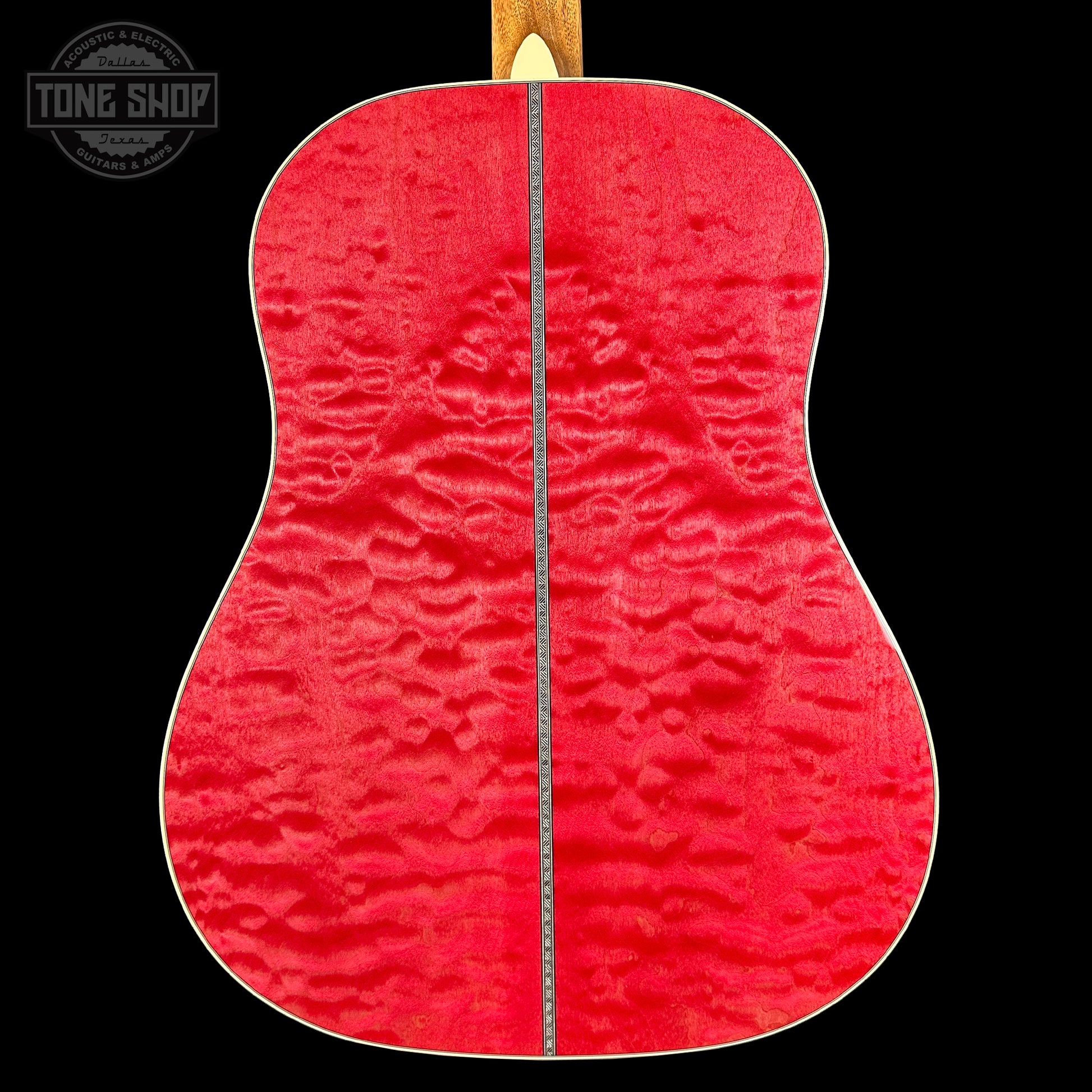Close-up of a red guitar back with a visible brand logo in the corner.