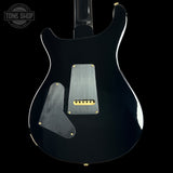 Black electric guitar with visible brand logo on a black background