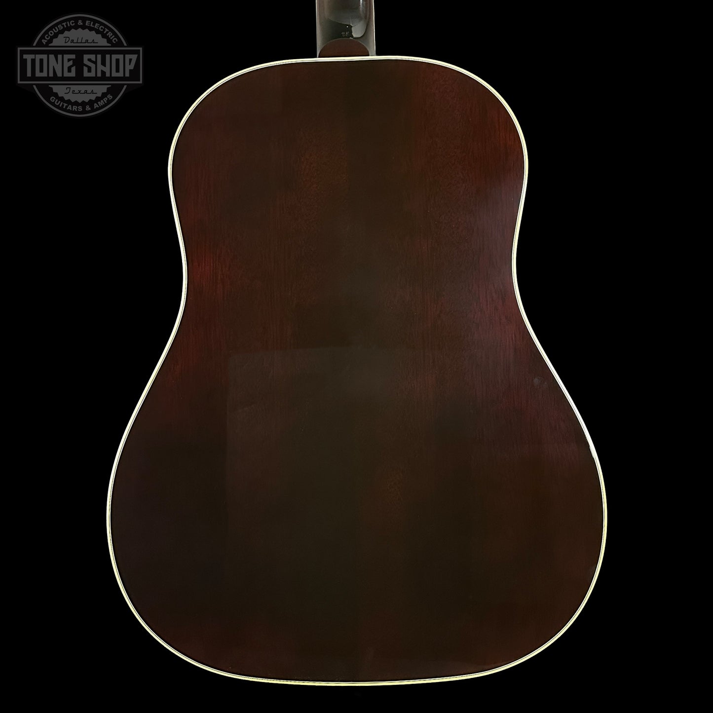 Back view of a wooden acoustic guitar with 'Tone Shop' logo.