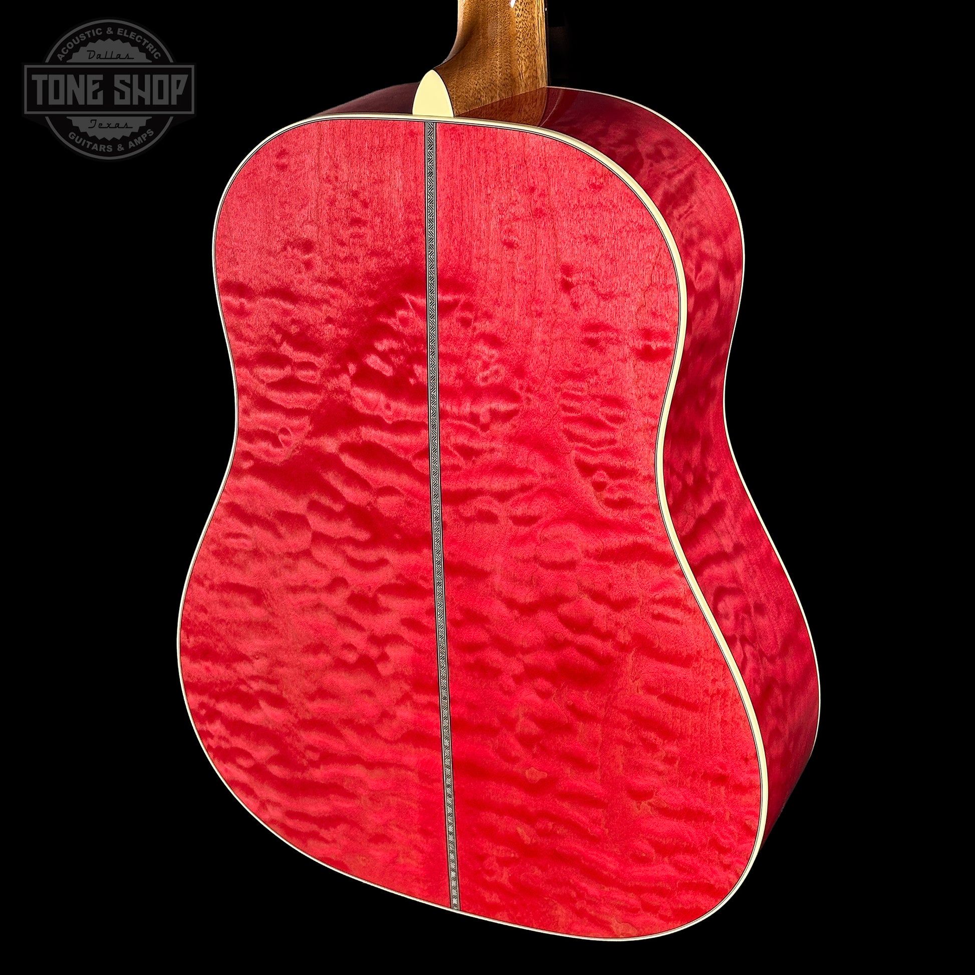 Red acoustic guitar with a visible brand logo in the corner