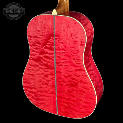 Red acoustic guitar with a visible brand logo in the corner