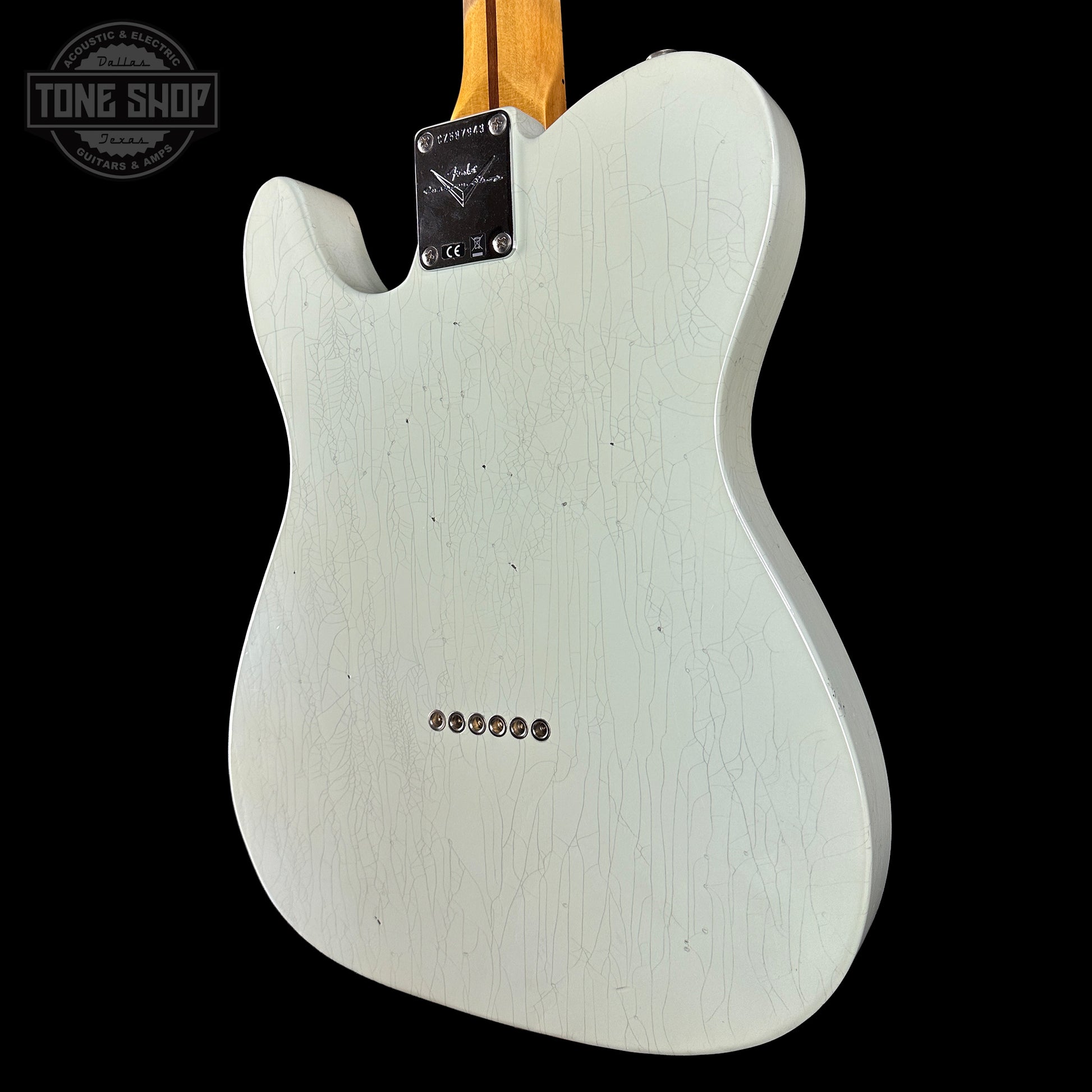 Back view of a white electric guitar with a visible brand logo on a black background.