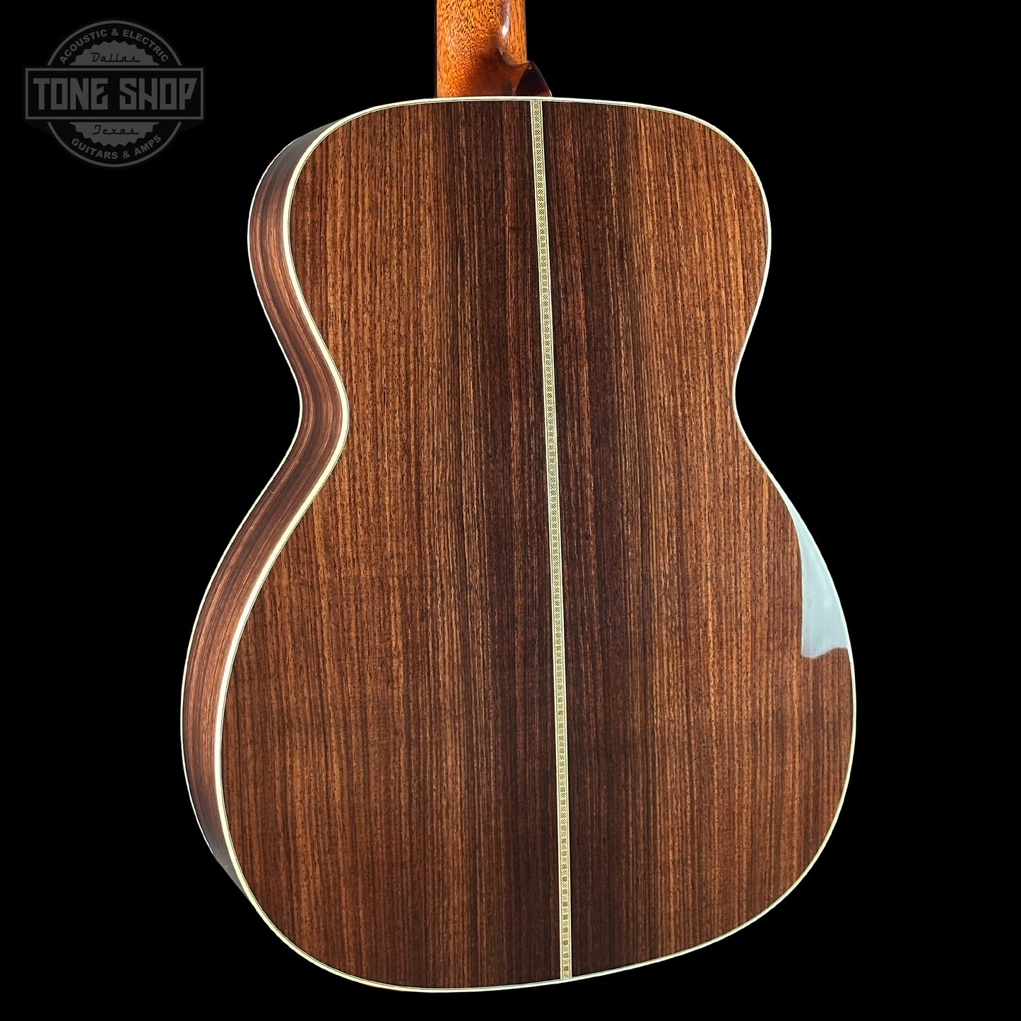 Back view of a wooden acoustic guitar with a visible brand logo in the corner.
