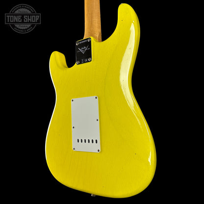Yellow electric guitar body with a visible brand logo on a black background
