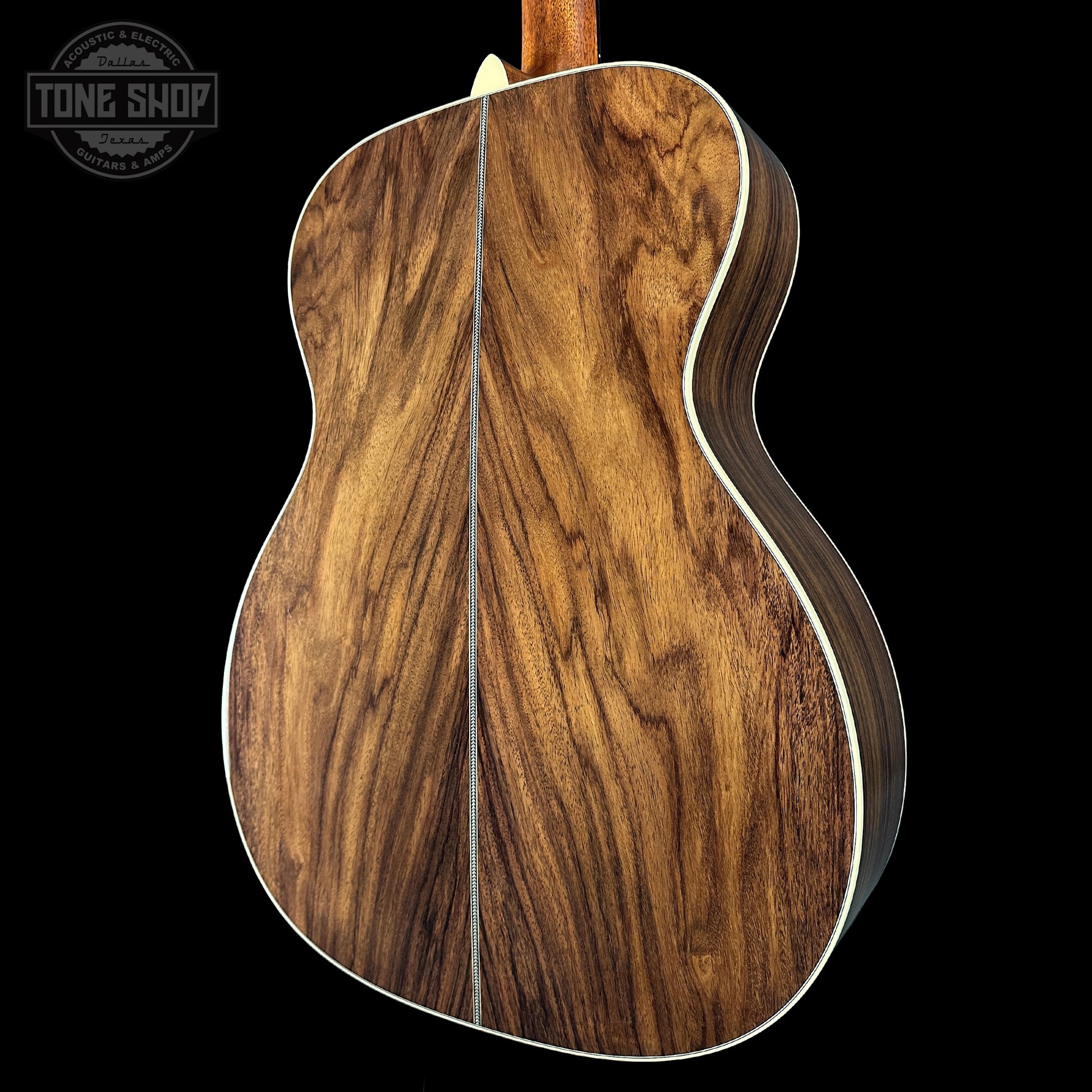 Close-up of a wooden acoustic guitar body with 'Tone Shop' branding.