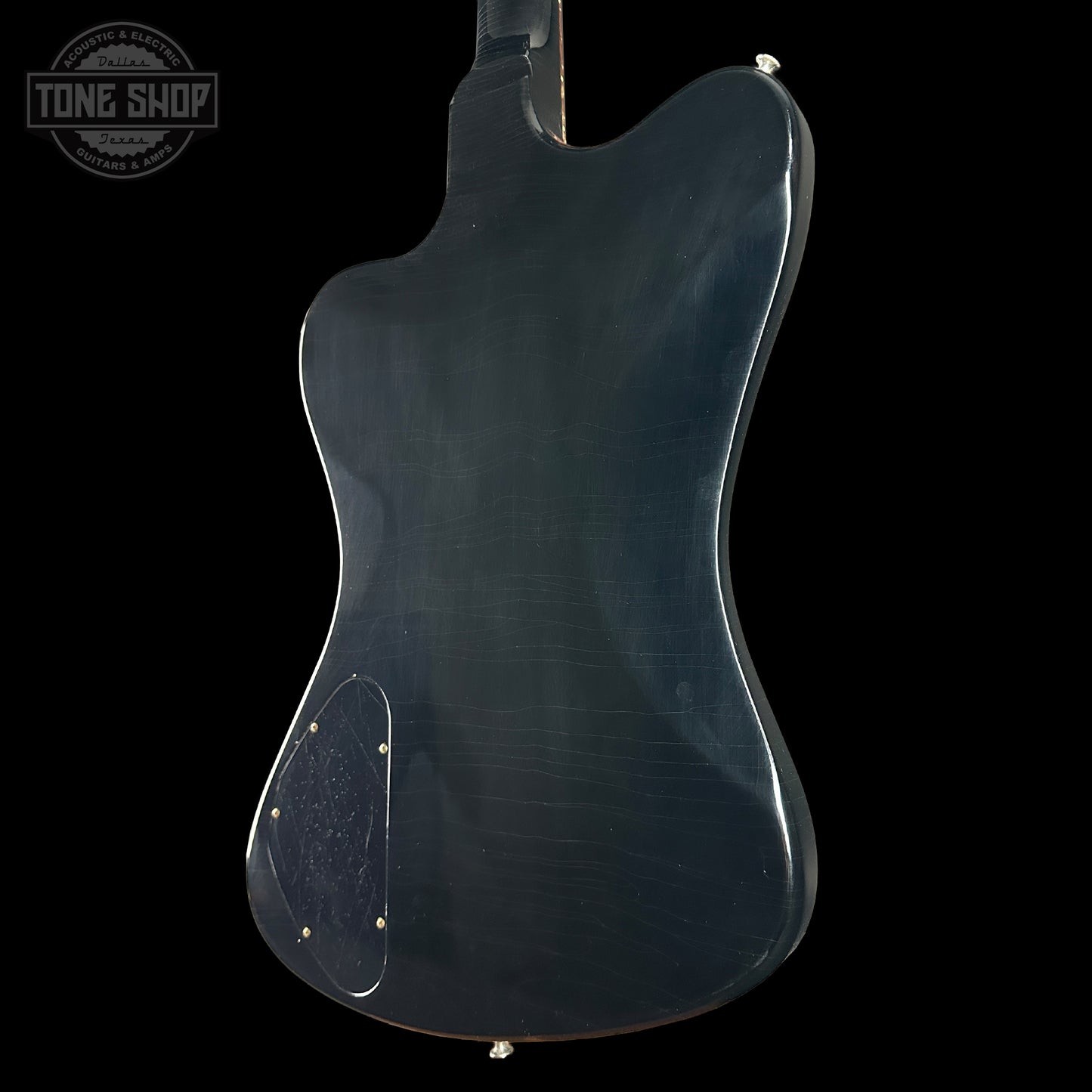 Back view of a blue electric guitar on a black background with 'Tone Shop' logo.