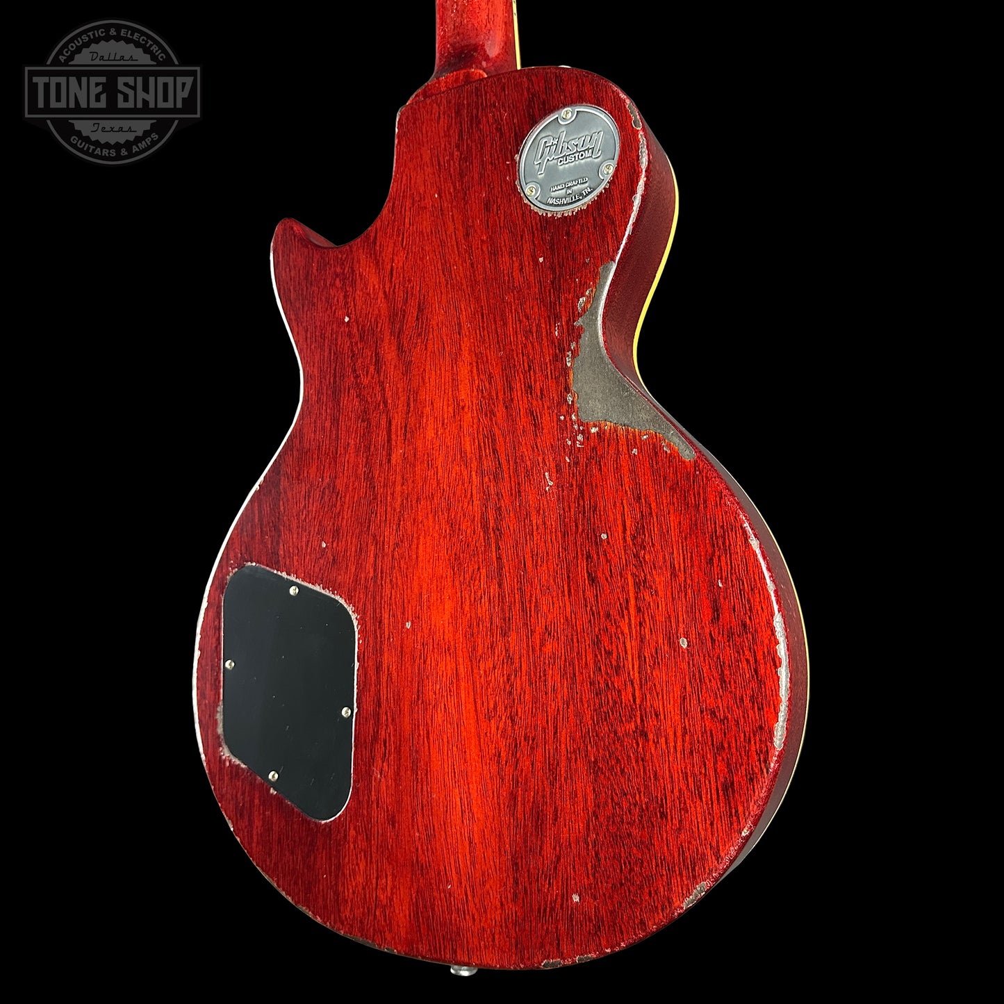 Red electric guitar body with a visible brand logo on a black background