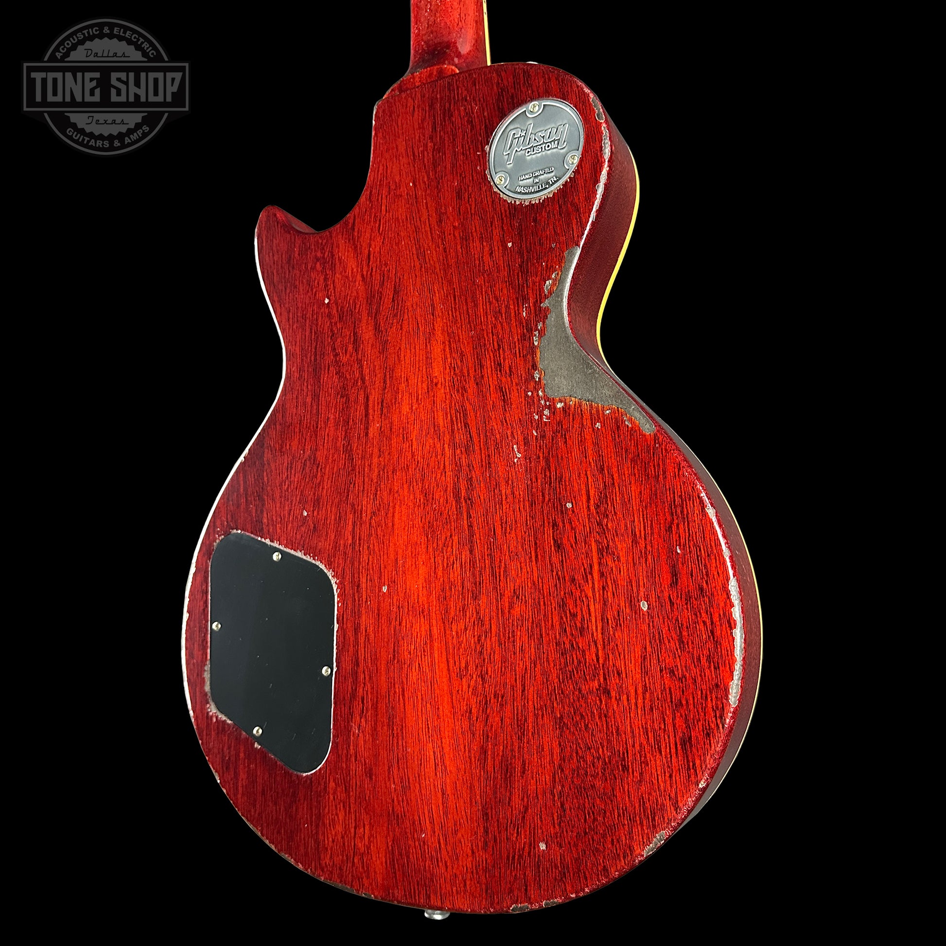 Red electric guitar body with a visible brand logo on a black background