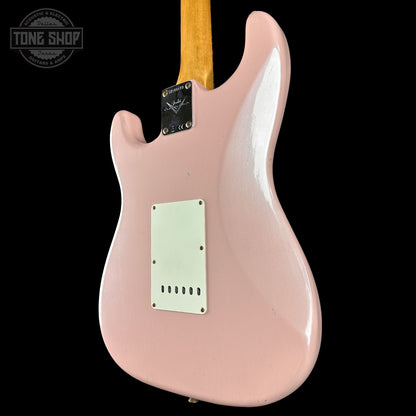 Pink electric guitar body with a visible brand logo on a black background