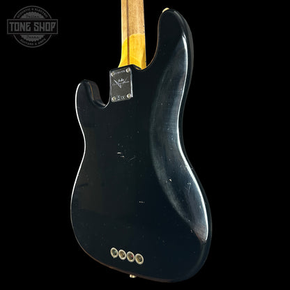 Black electric guitar with a visible Fender logo on a black background
