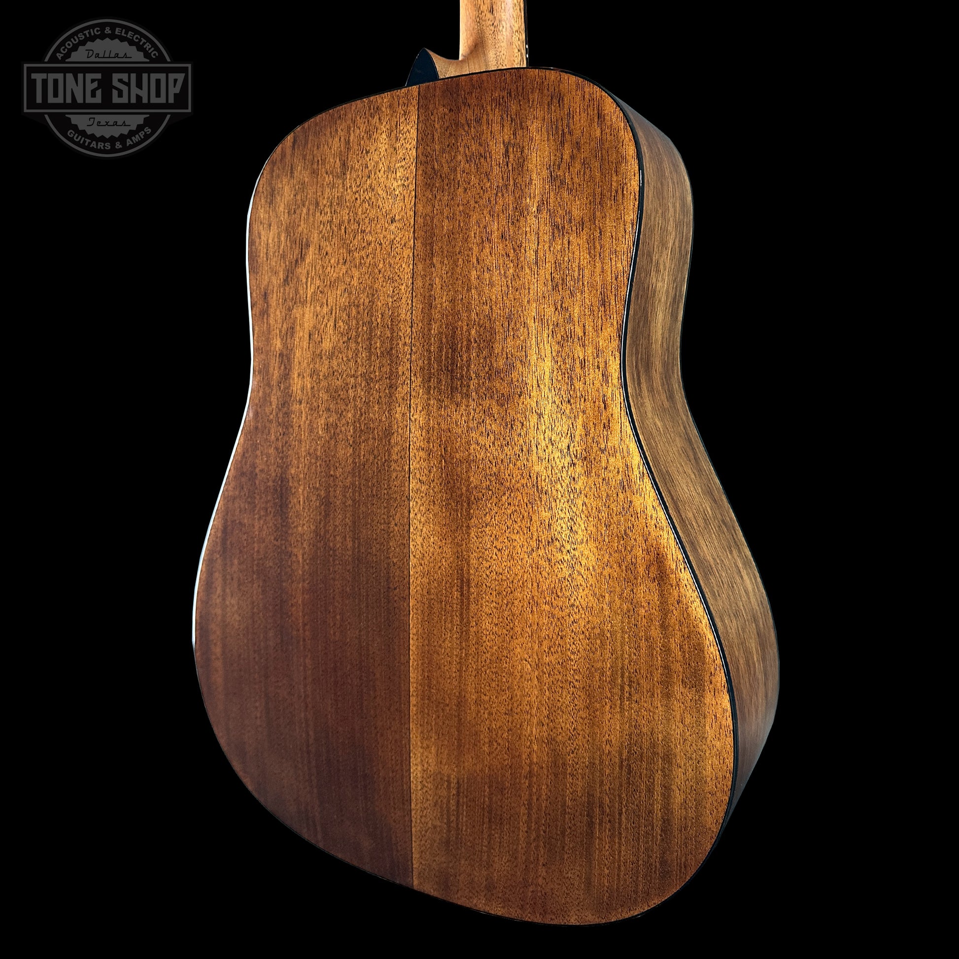 Close-up of a wooden acoustic guitar back with 'Tone Shop' logo.