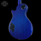 Blue electric guitar body with a 'Tone Shop' logo in the corner.