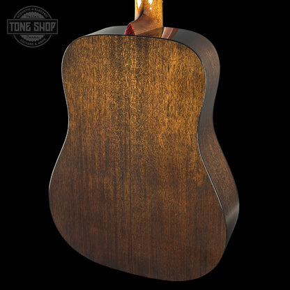Close-up of a wooden acoustic guitar back with 'Tone Shop' logo.