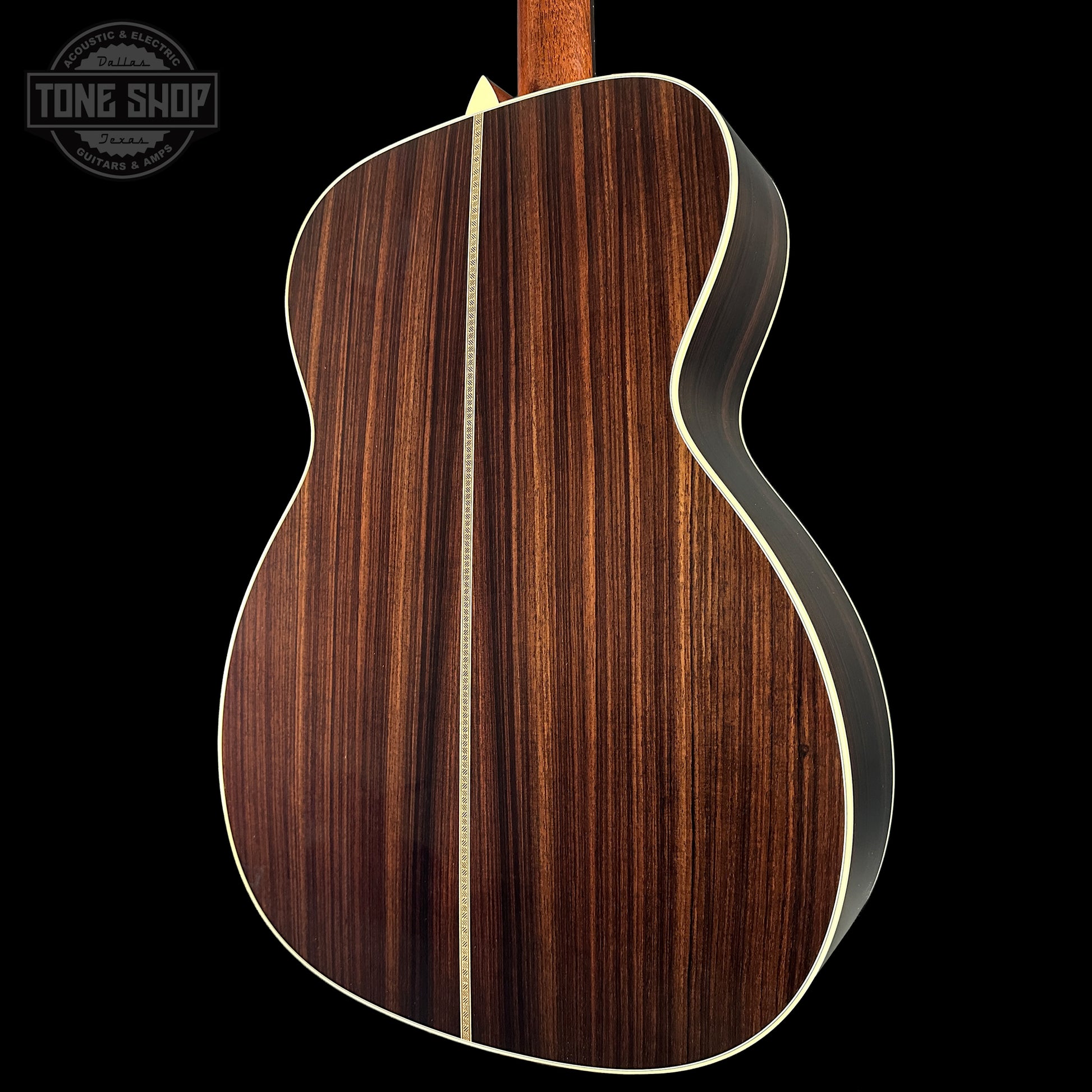 Back view of a wooden acoustic guitar with a visible brand logo in the corner.