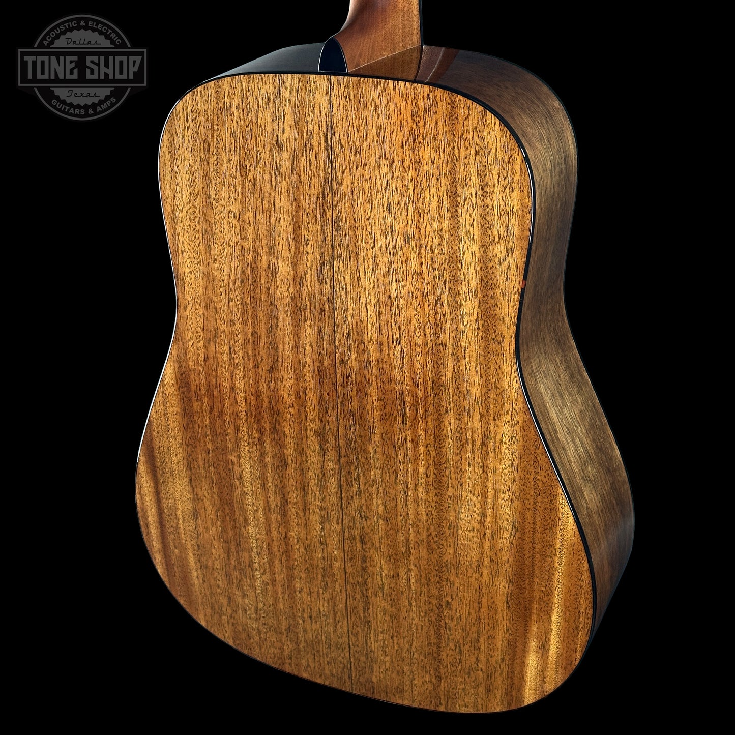 Close-up of a wooden acoustic guitar body with 'Tone Shop' logo in the corner.