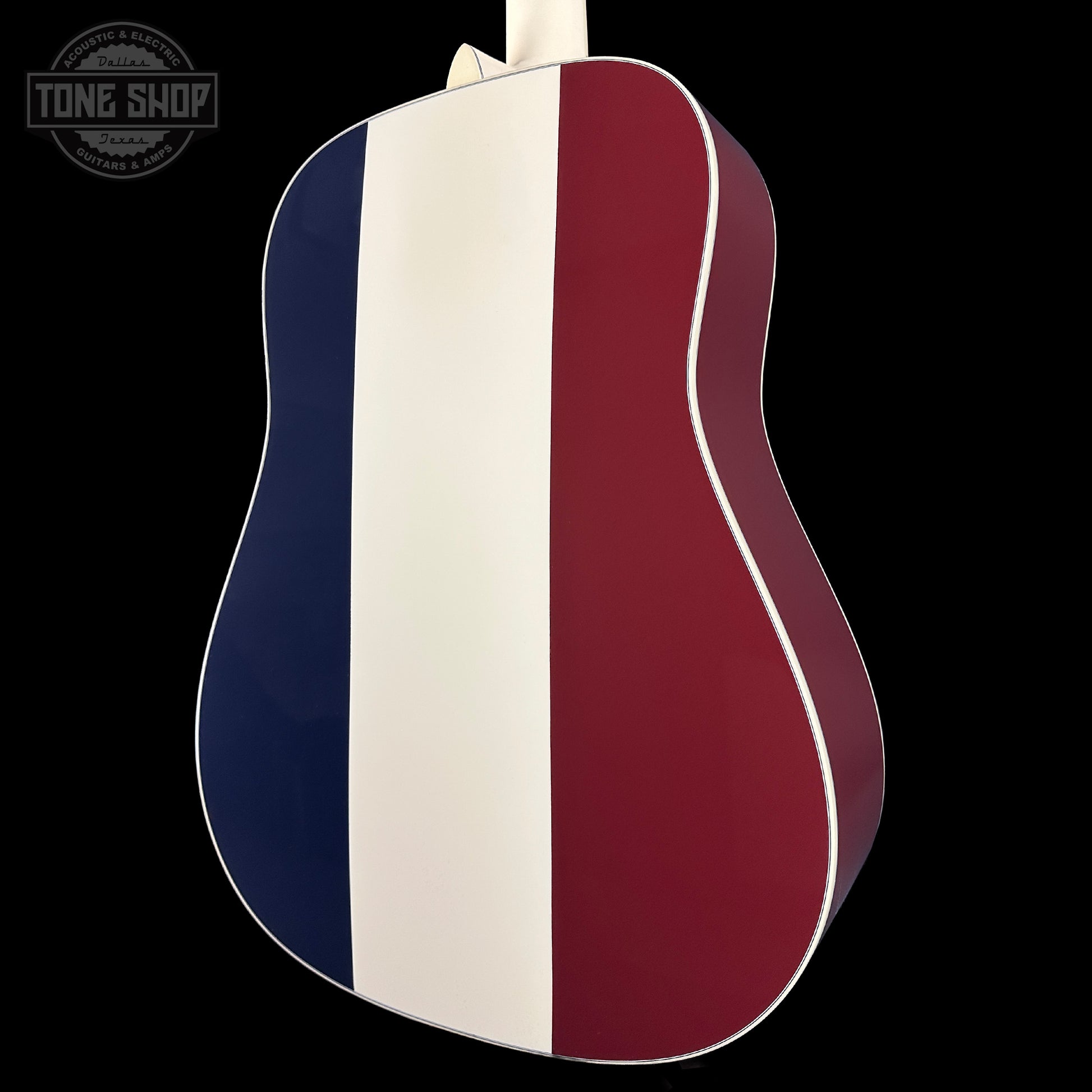 Acoustic guitar with a striped design on a black background, featuring the Tone Shop logo.