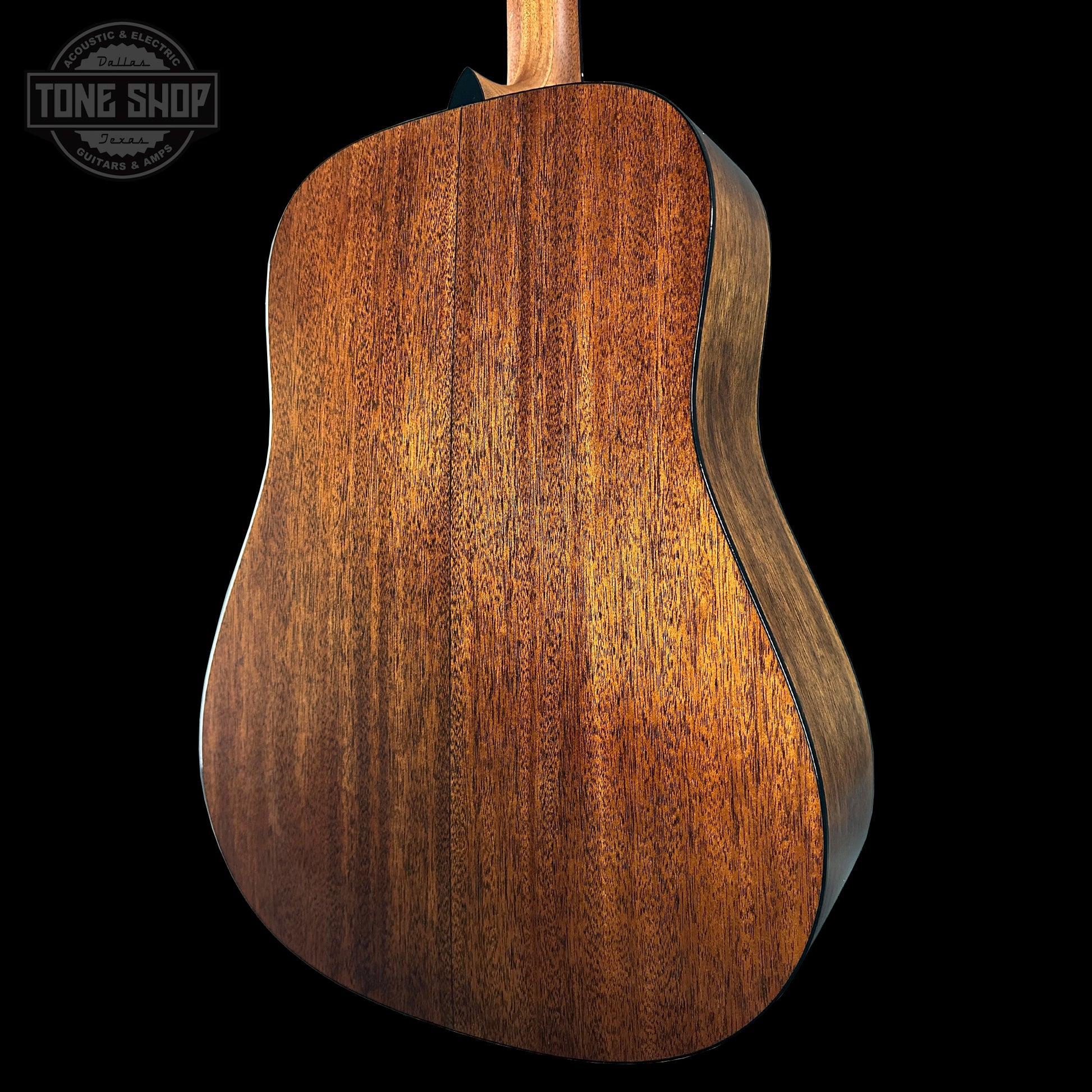 Close-up of a wooden acoustic guitar body with 'Tone Shop' logo.