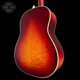 Back view of a red acoustic guitar with a visible brand logo in the corner.