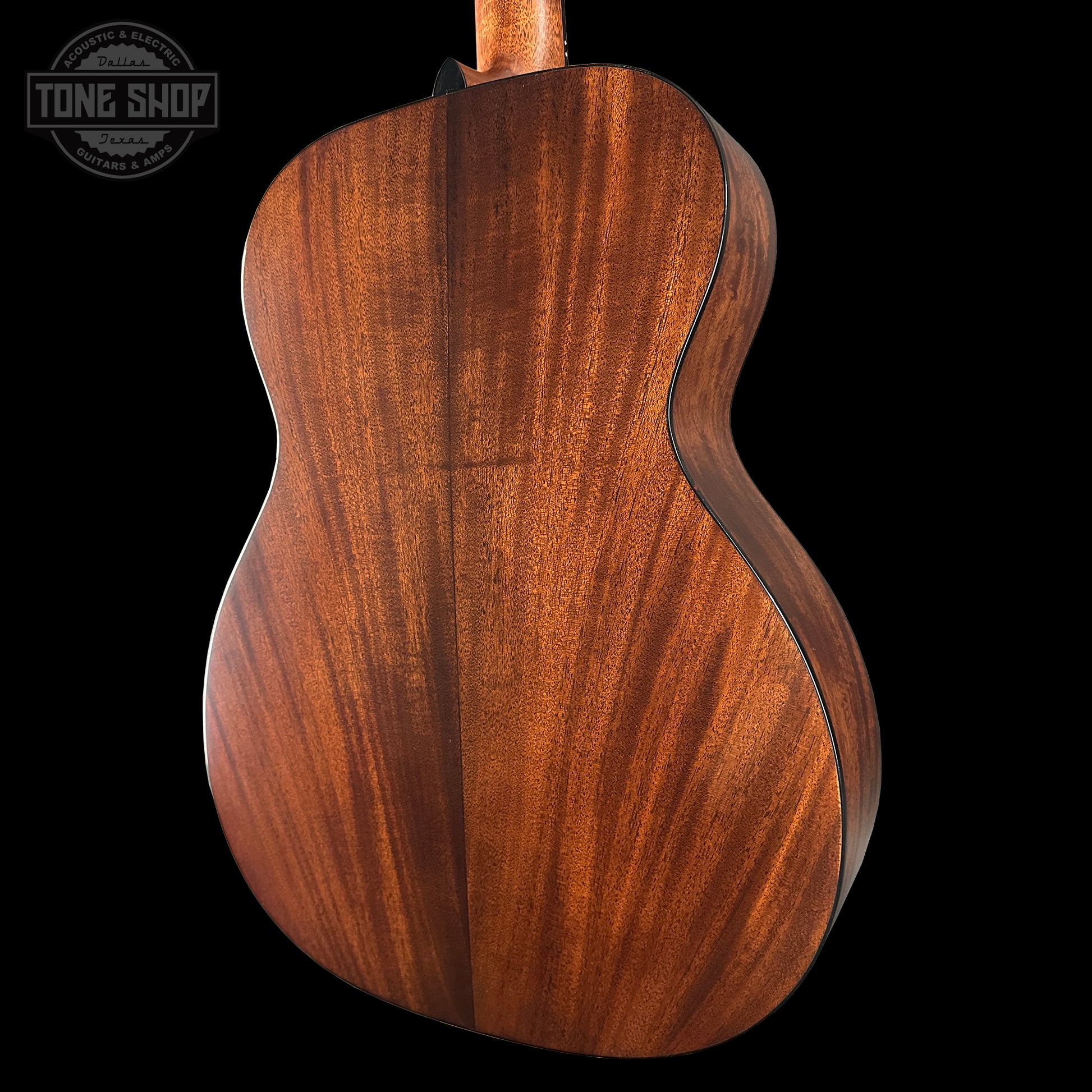 Close-up of a wooden acoustic guitar on a black background with 'Tone Shop' logo.