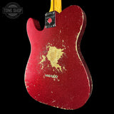 Red distressed electric guitar with gold paint splatter on a black background, featuring 'Tone Shop' branding.
