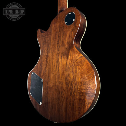 Wooden electric guitar body with 'Tone Shop' logo in the corner