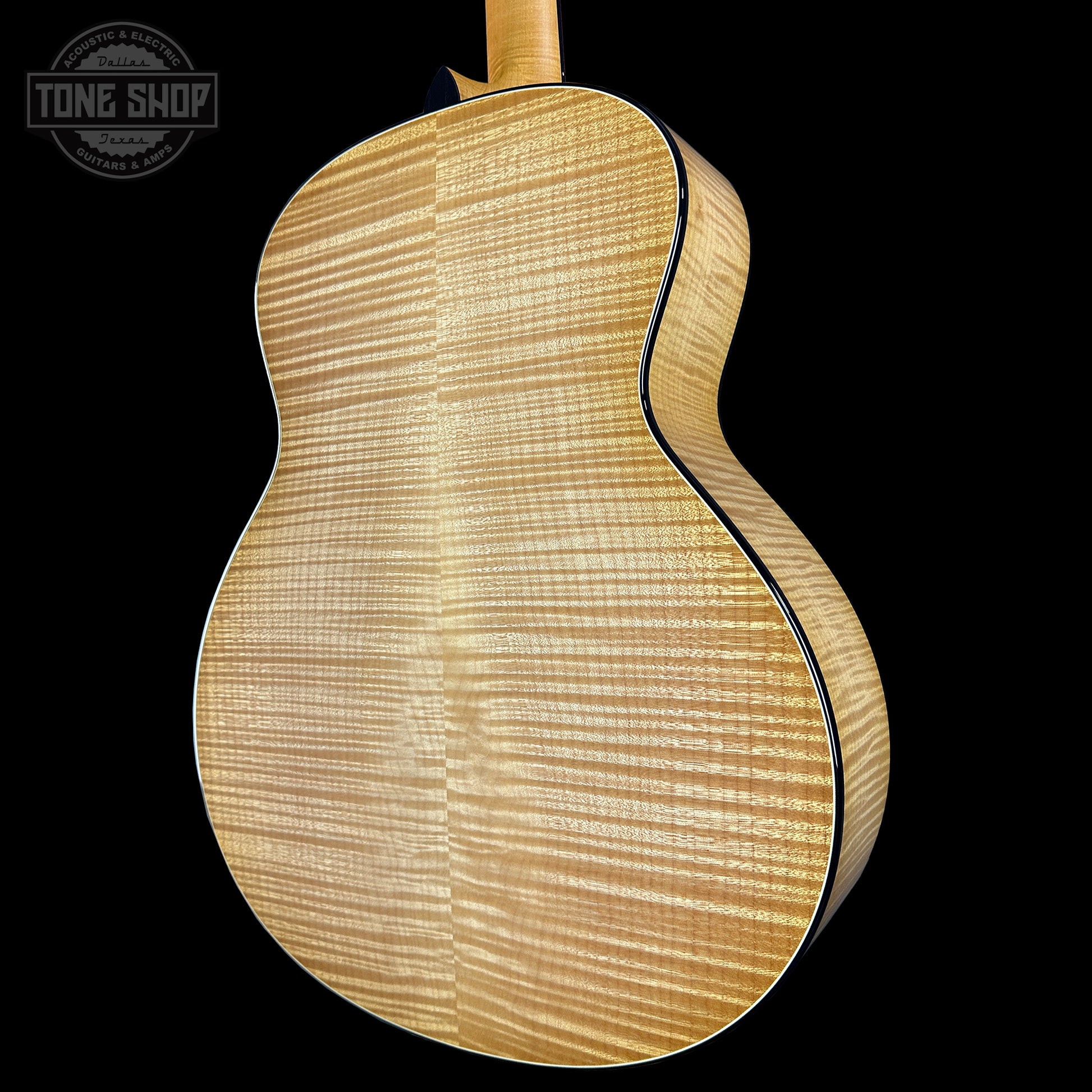 Close-up of a wooden acoustic guitar on a black background with 'Tone Shop' logo.