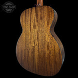 Close-up of a wooden acoustic guitar body with 'Tone Shop' logo.