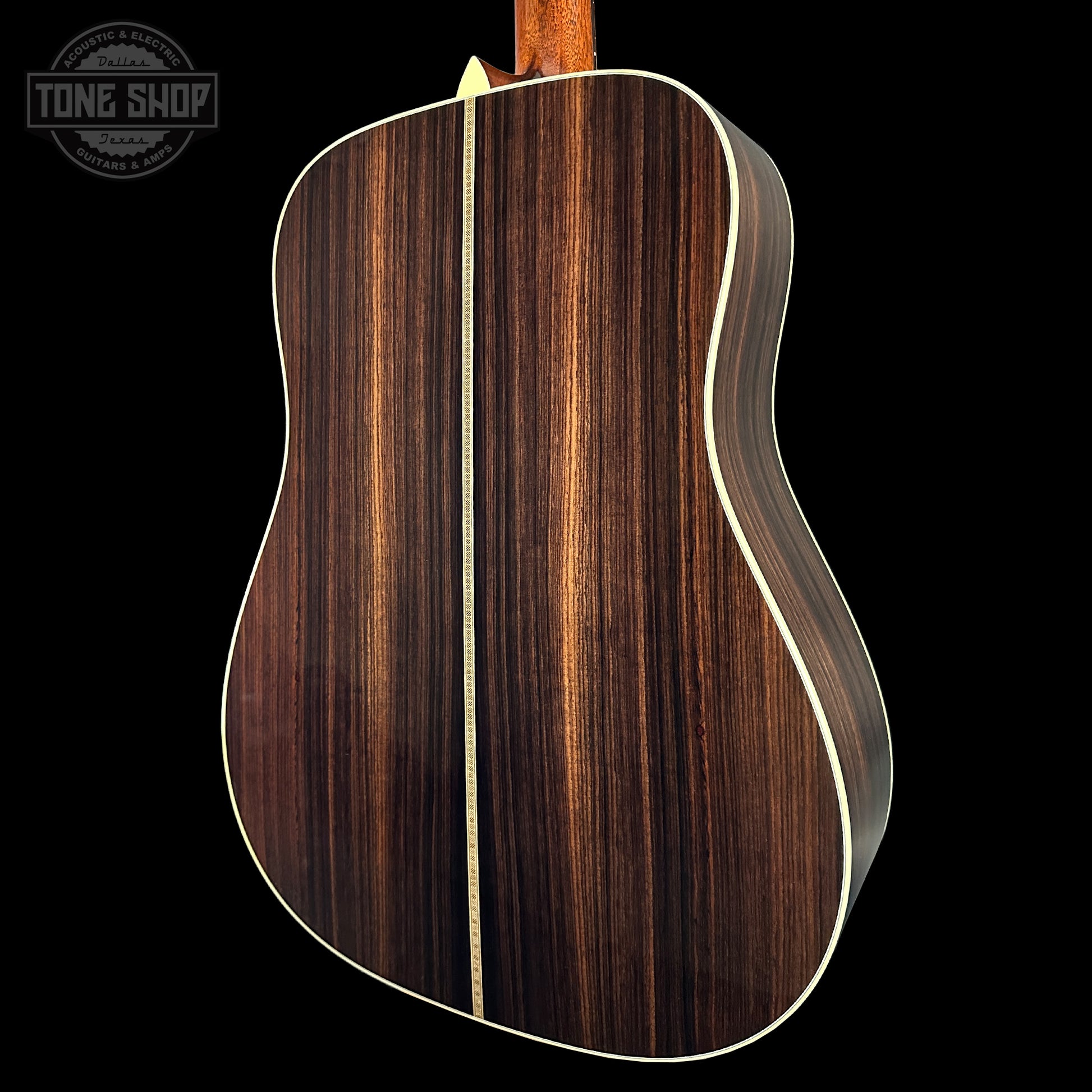 Acoustic guitar with a wooden finish on a black background, featuring the Tone Shop logo.