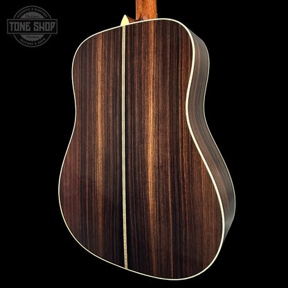 Acoustic guitar with a wooden finish on a black background, featuring the Tone Shop logo.