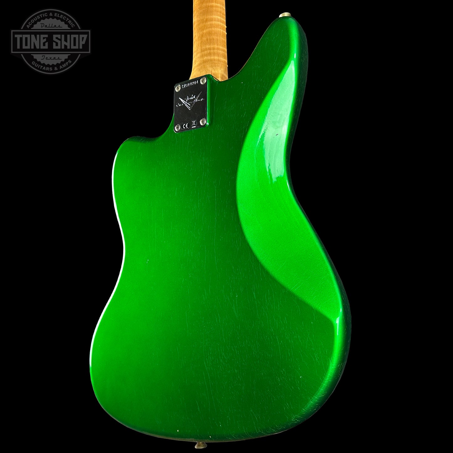 Green electric guitar body with a visible brand logo on a black background