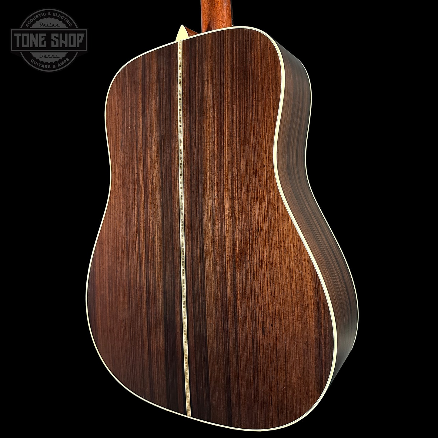 Close-up of a wooden acoustic guitar with a visible brand logo in the corner.