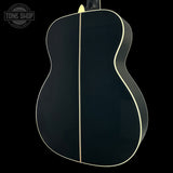 Black acoustic guitar body with a visible brand logo in the corner.