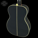 Black acoustic guitar with a white line on a black background, featuring the Tone Shop logo.