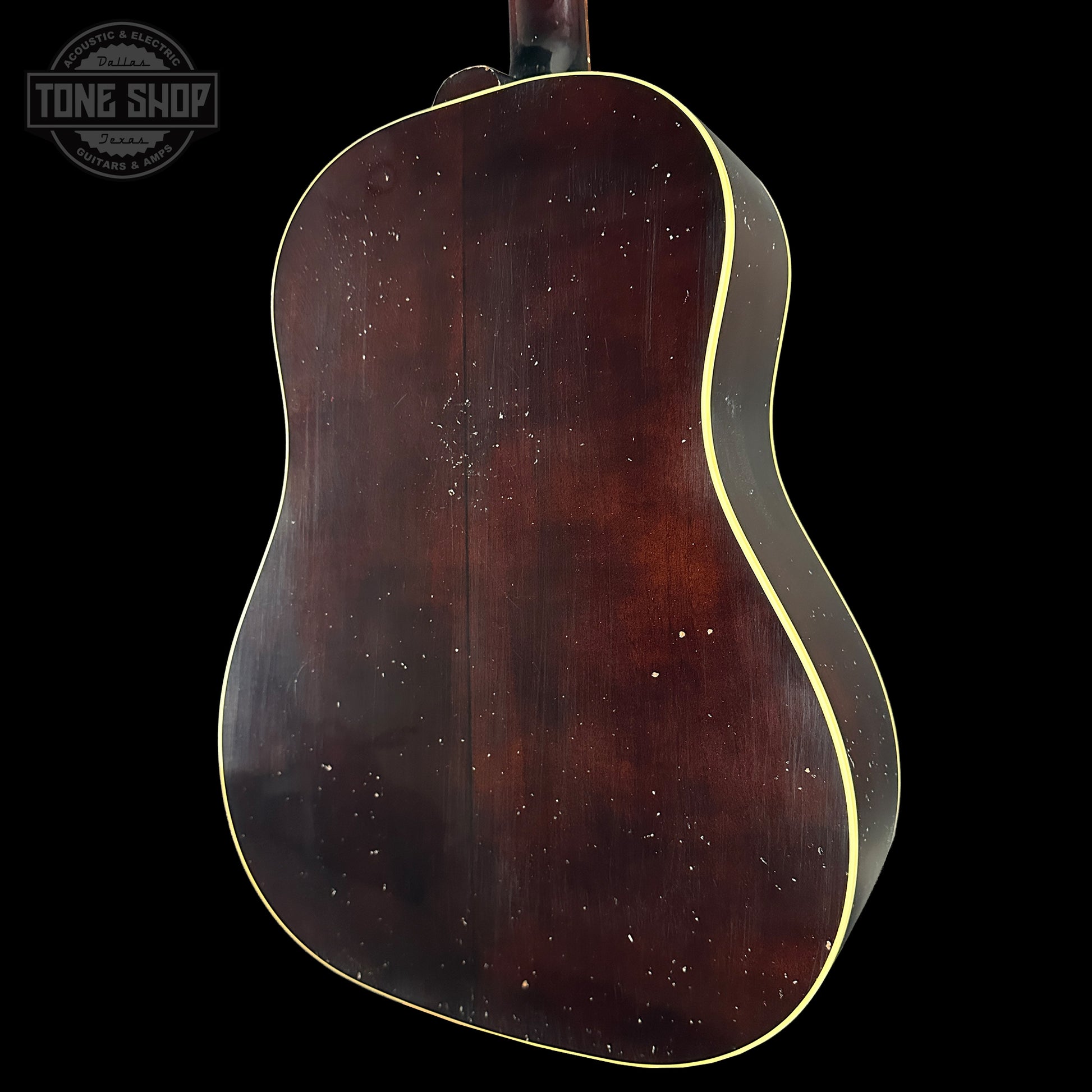 Back view of a guitar with a dark brown finish on a black background, featuring the Tone Shop logo.