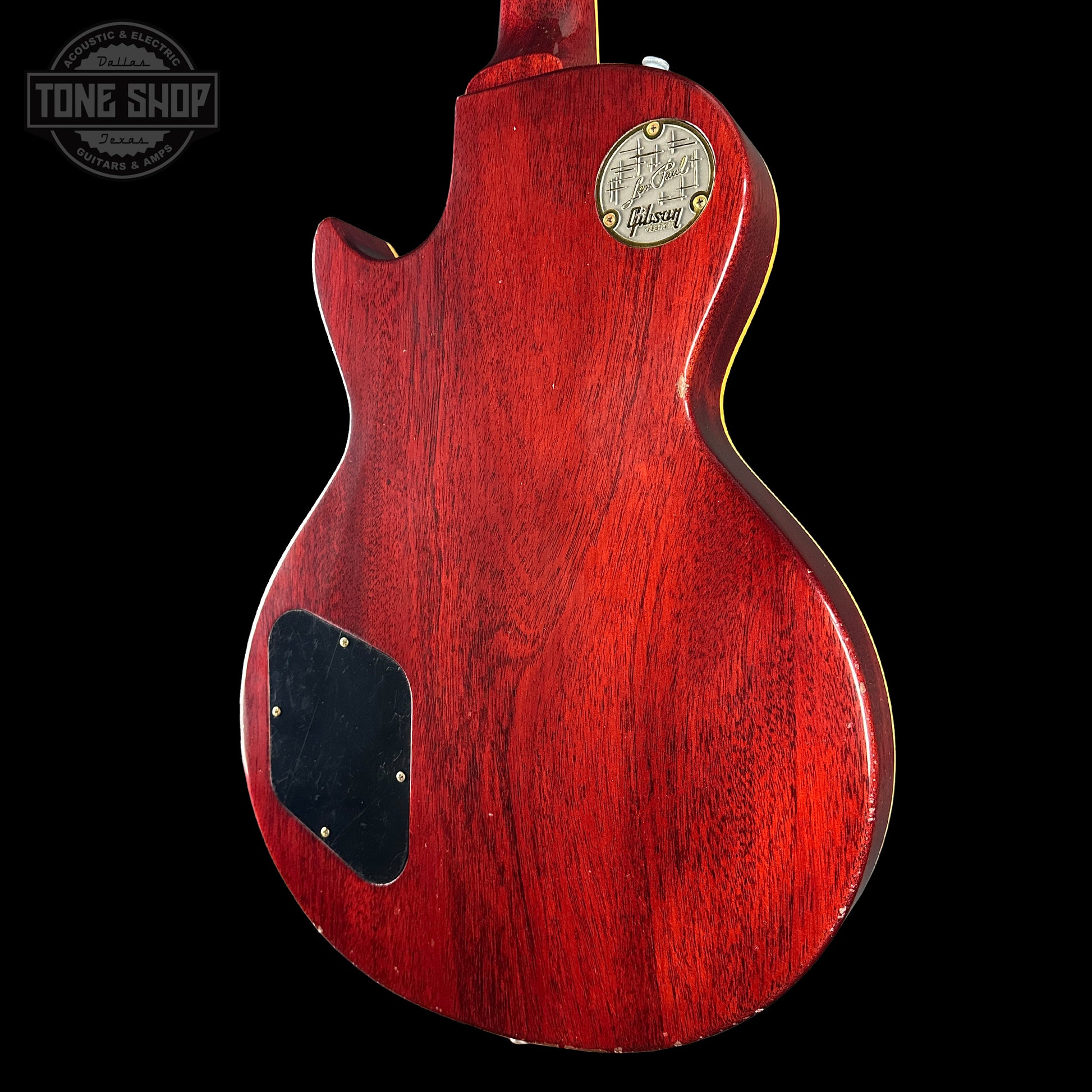 Red electric guitar body with Gibson logo on a black background