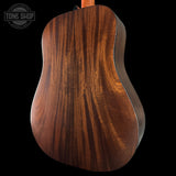 Close-up of a wooden guitar back with 'Tone Shop' logo in the corner.