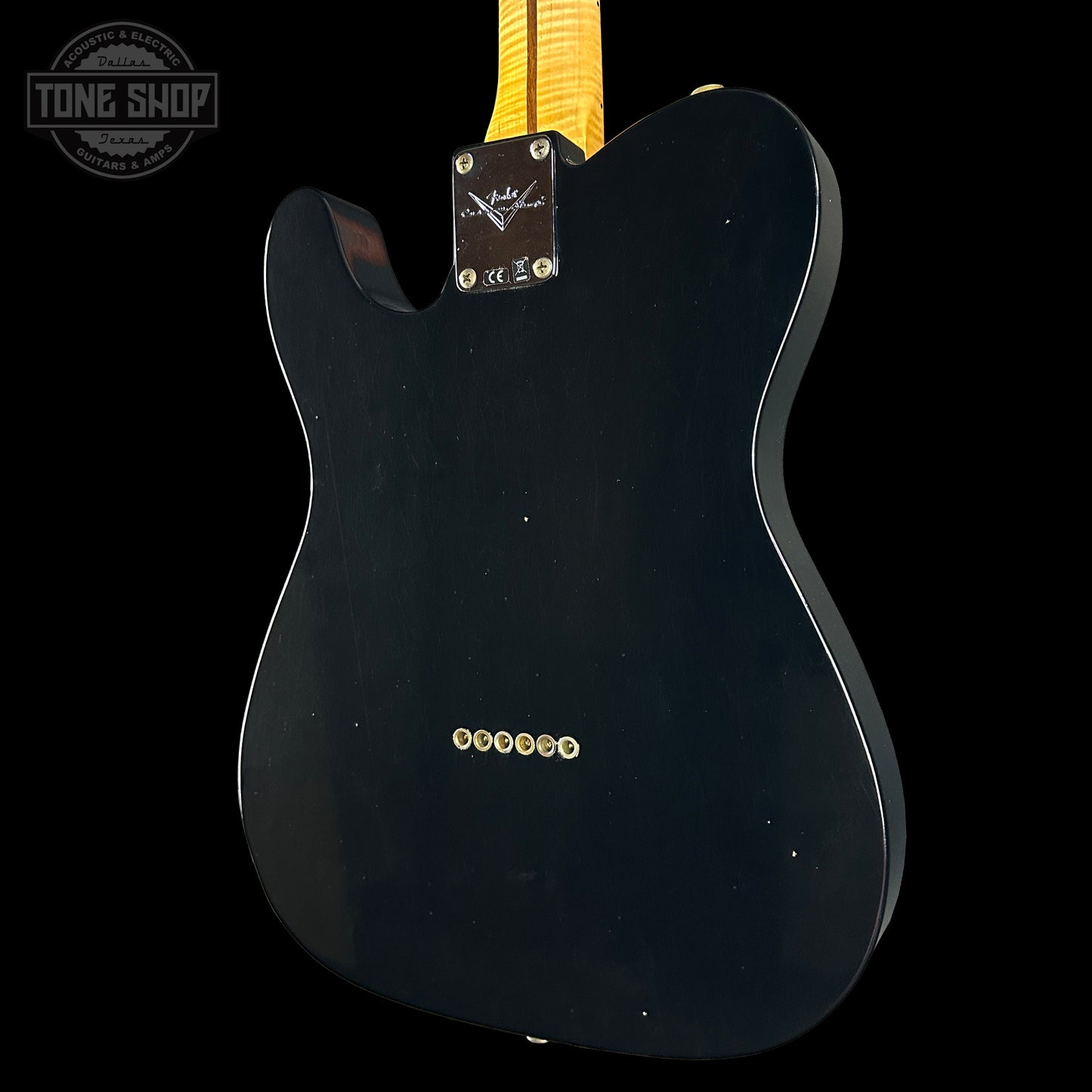 Black electric guitar body with 'Tone Shop' logo in the corner