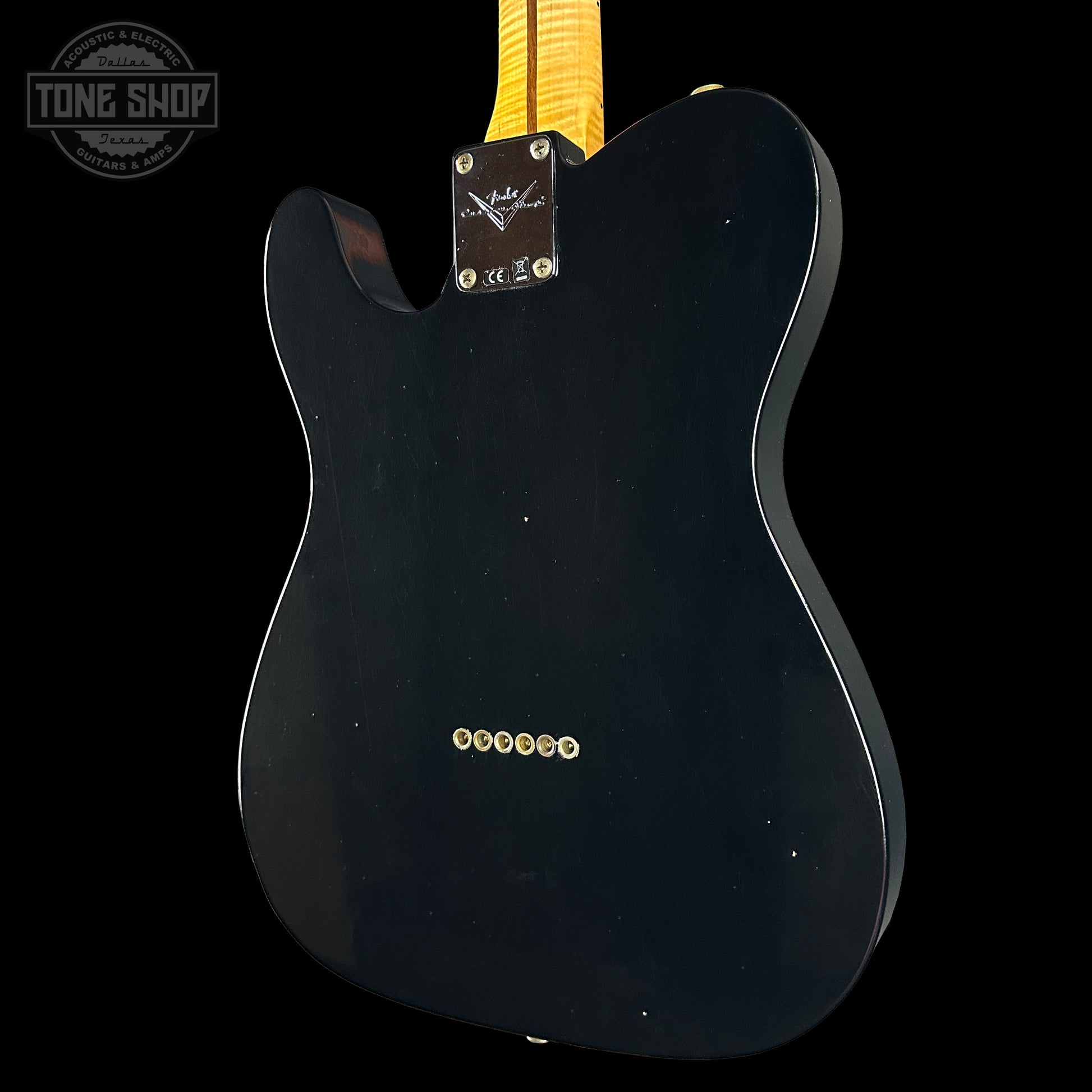 Black electric guitar body with 'Tone Shop' logo in the corner