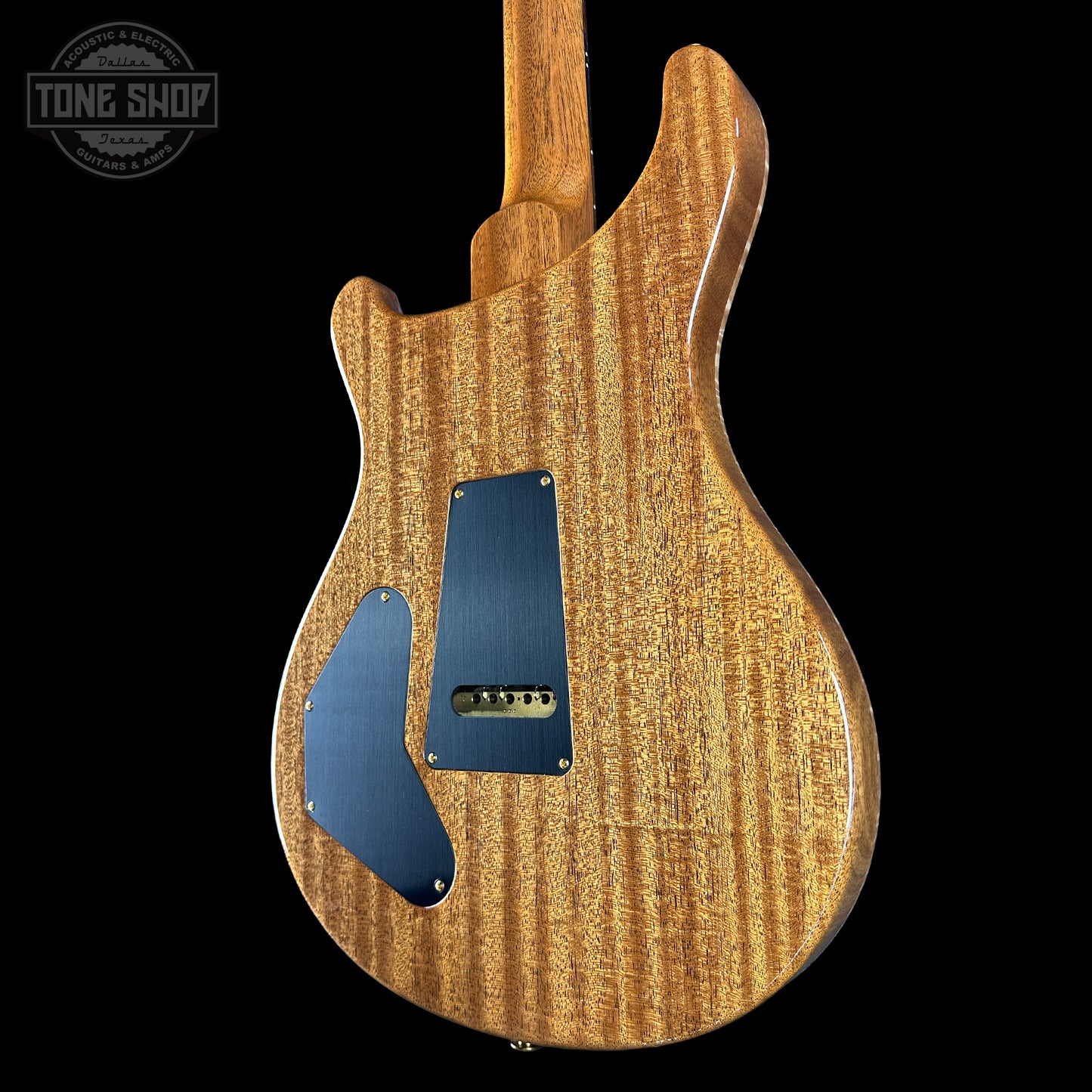 Back view of a wooden electric guitar with a blue pickguard on a black background, featuring 'Tone Shop' branding.