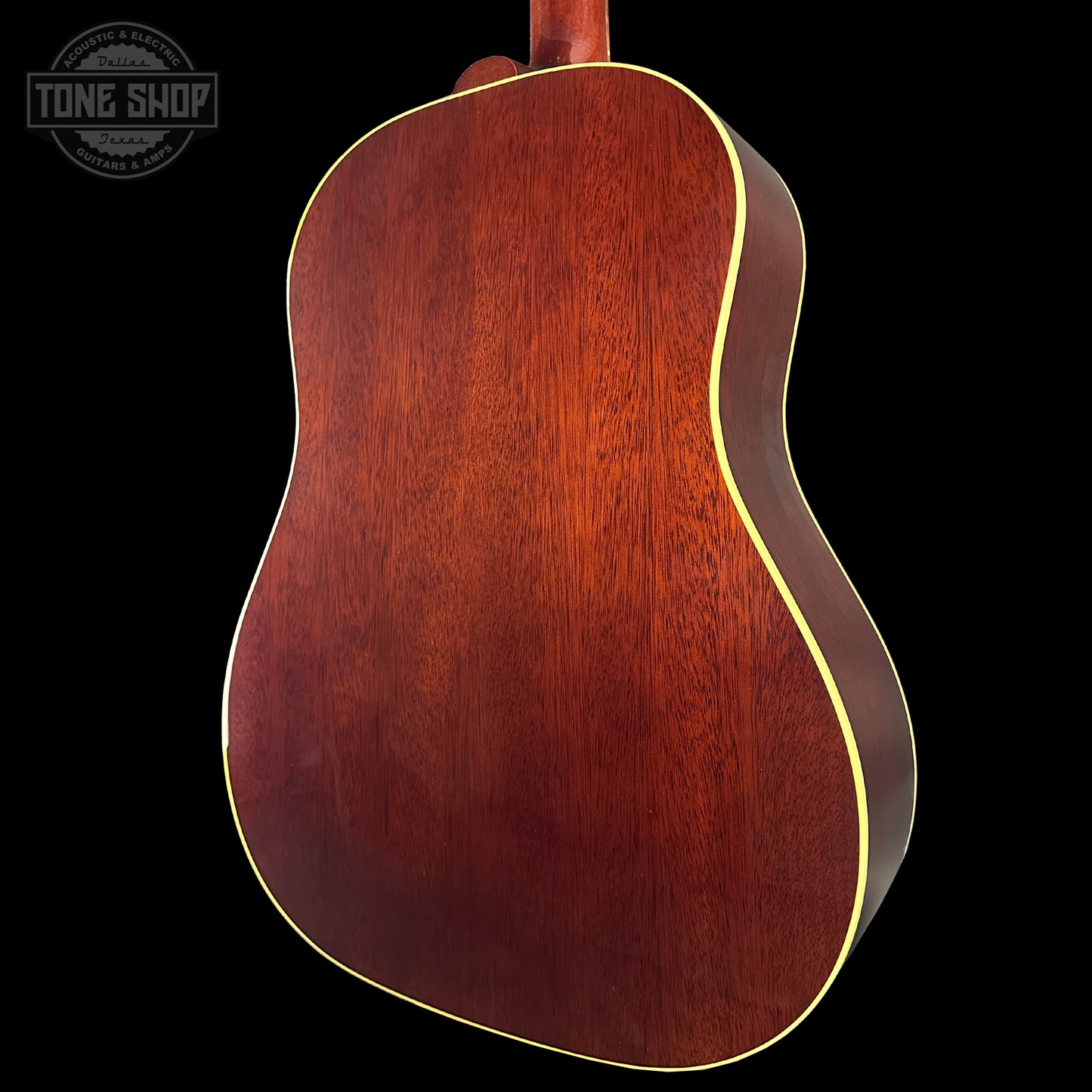 Back view of a wooden acoustic guitar with 'Tone Shop' logo in the corner.