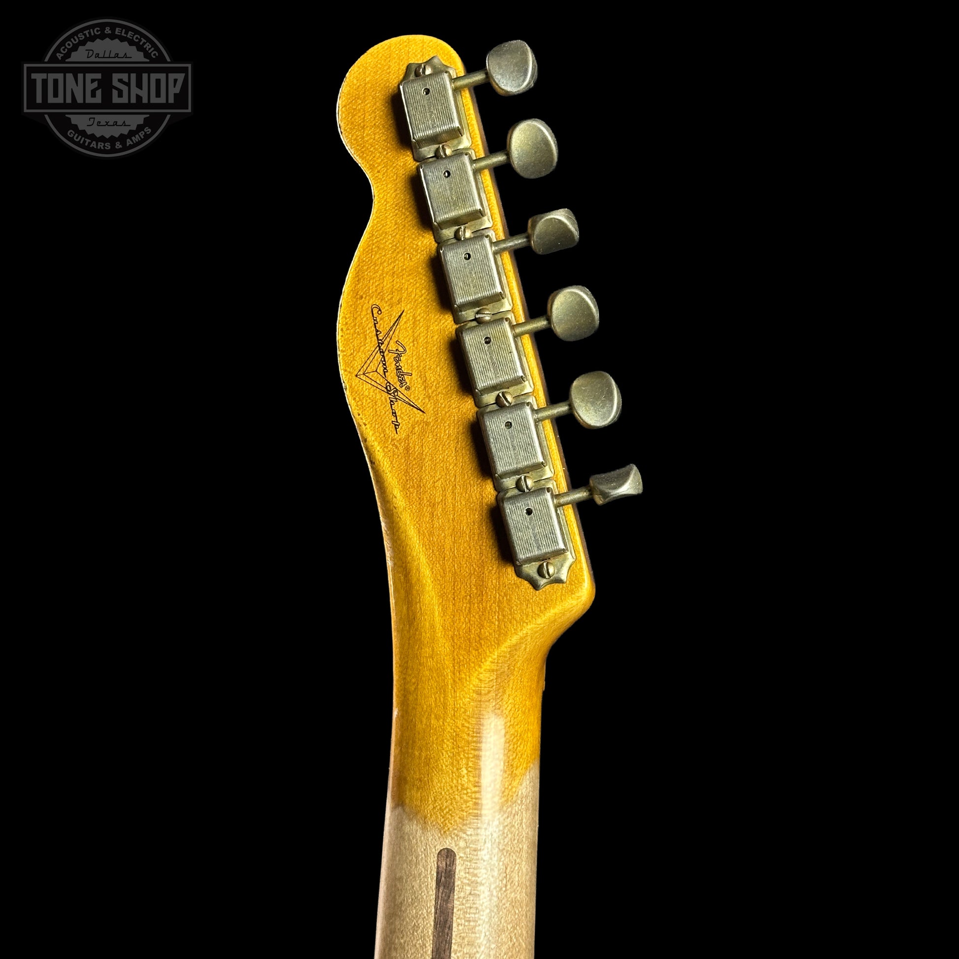 Guitar headstock with tuning pegs on a black background, featuring the Tone Shop logo.