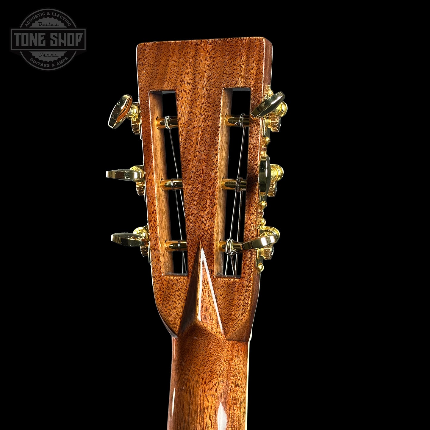 Close-up of a guitar headstock with tuning pegs on a black background, featuring 'Tone Shop' branding.