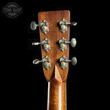 Close-up of a guitar headstock with tuning pegs on a black background, featuring the Tone Shop logo.