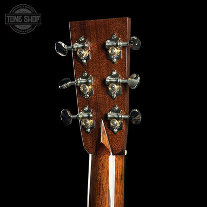 Close-up of a guitar headstock with tuning pegs on a black background, featuring the Tone Shop logo.