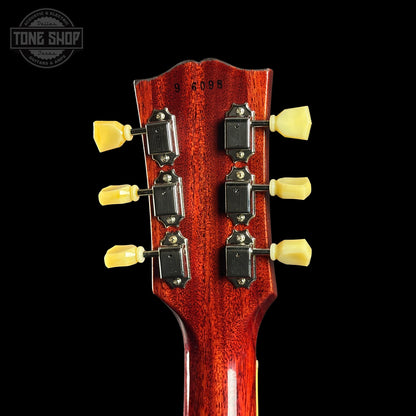 Close-up of a guitar headstock with tuning pegs on a black background, featuring the Tone Shop logo.